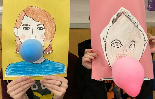 Two students hold up art projects during an elementary student visit to Salisbury Composite High.