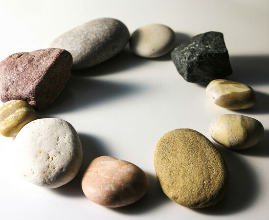 A white counter with a circle of unique rocks sitting on it.
