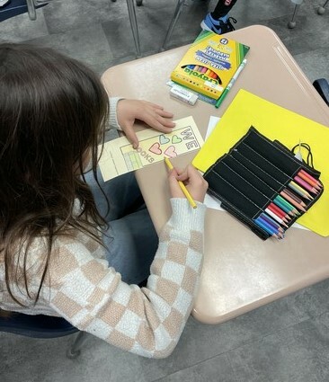 A student from Glen Allan Elementary colours one of the bookmarks being given to Indigo Sherwood Park customers who donate to the school’s Indigo Adopt a School campaign this year.