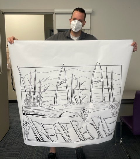 Randy Pond, an art teacher at Vegreville Composite High, holds up a banner designed for National Indigenous Peoples Day.