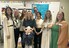 Eight staff stand in a classroom and smile at the camera. The whiteboard behind them has different tools for reading strategies.