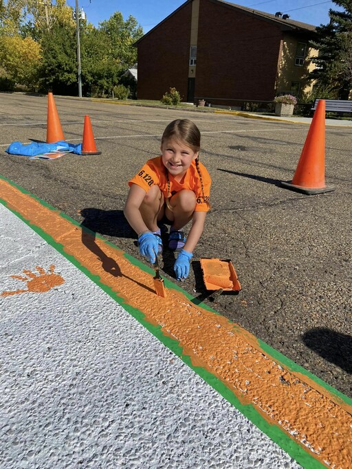 Bruderheim School student, McKenna Bonner, paints a town sidewalk for the National Day for Truth and Reconciliation.