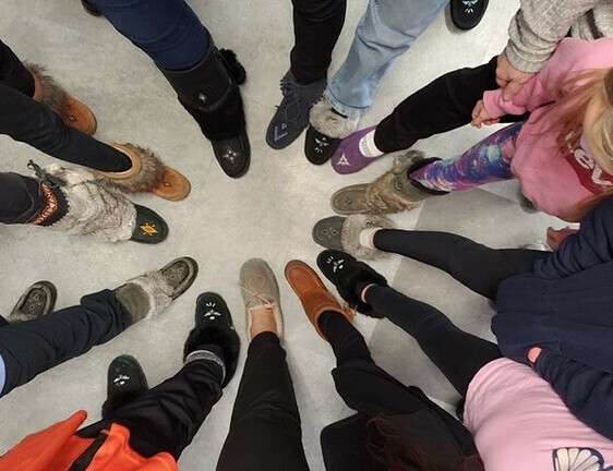 Circle of adult feet all wearing moccasins